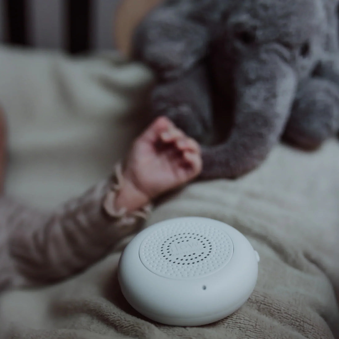 Baby sover roligt med Flow Amsterdam White Noise-bamse, der skaber tryghed ved puttetid.