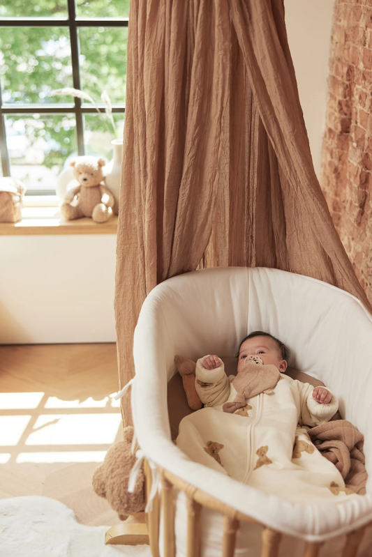 Baby i Jollein Teddy sovepose med bamseprint og lange ærmer ligger i vugge