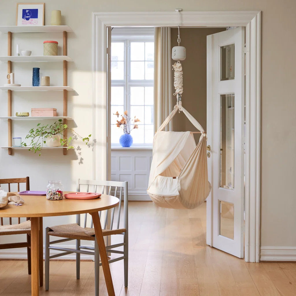 Membantu Premium slyngevugge Nature monteret i loftophæng og klar til babyens lur i et roligt hjemmemiljø.

