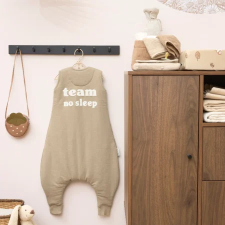 Sovedragt med ben i beige fra Meyco med teksten "team no sleep" – komfortabel og sikker sovepose til børn
