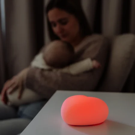 Ammelampe med blødt lys ved natamning – mor sidder med baby i sengen | MrsMama