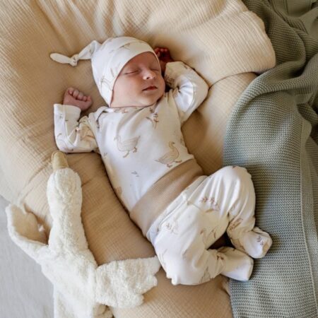 Sovende baby iført baby sæt i bomuld med Happy Goose motiv – hue, bluse og bukser i blødt og allergivenligt materiale.