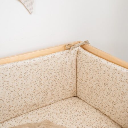 Sengerand til baby i beige bomuld med fint bladmotiv – blød og sikker beskyttelse til tremmeseng 120x60 cm.