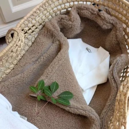 Kørepose i uld til autostol i brown uld fra Zaffiro i tæt lifestyle-closeup i kurv