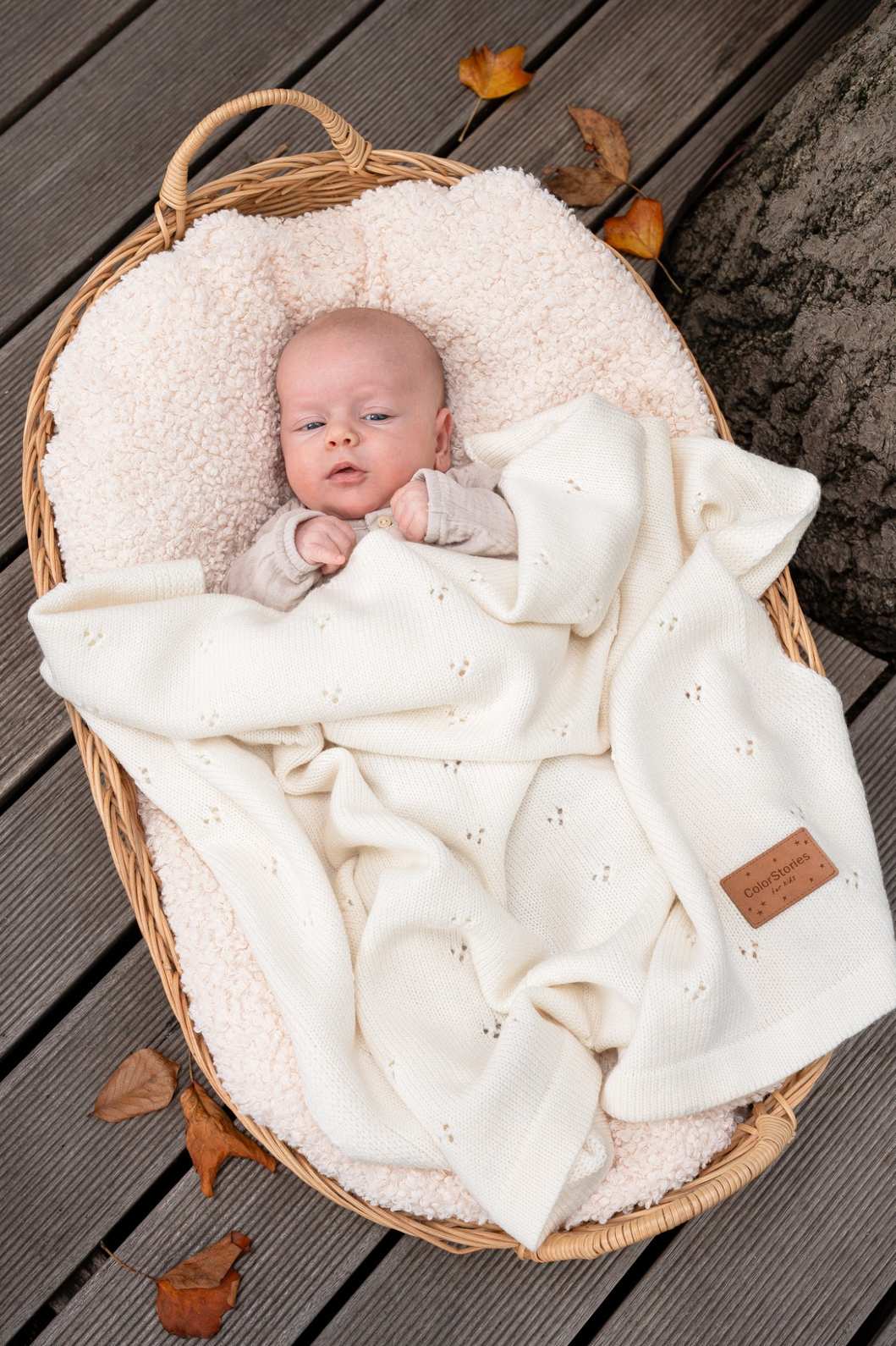Baby ligger trygt under et blødt merino babytæppe i cremefarvet uld – naturligt og åndbart tæppe til baby