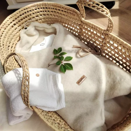 Svøb kørepose i beige uld fra Zaffiro vist som lifestyle-opstilling i Moseskurv