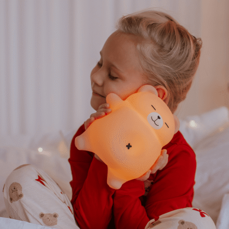Bjørn natlampe til børn – blød og beroligende LED natlampe fra MARY'S, holdt af barn i sengen.