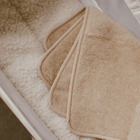 Uldtæppe i merinould foldet i barnevogn – blødt og temperaturregulerende babytæppe i 100% merinould