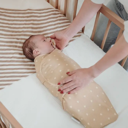 Baby svøbt i Swaddle babysvøb der skaber tryghed og bedre søvn i tremmeseng