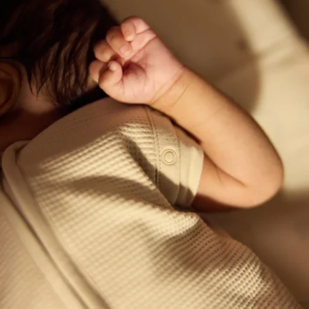 Baby sovepose newborn med svøb funktion – detalje af trykknapper ved skulder til at holde armene inde og skabe tryg søvn